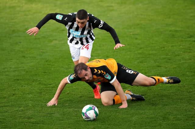 Matty Dolan of Newport County battles for possession with Miguel Almiron of Newcastle United during the Carabao Cup fourth round match between Newport County and Newcastle United at Rodney Parade on September 30, 2020 in Newport, Wales.