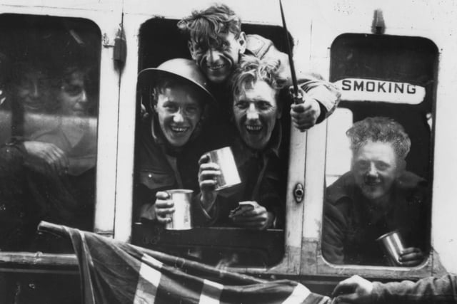 June 1940:  Members of the British Expeditionary Force arrive back in Britain with a Union Jack after being evacuated from Dunkirk.  (Photo by Keystone/Getty Images)