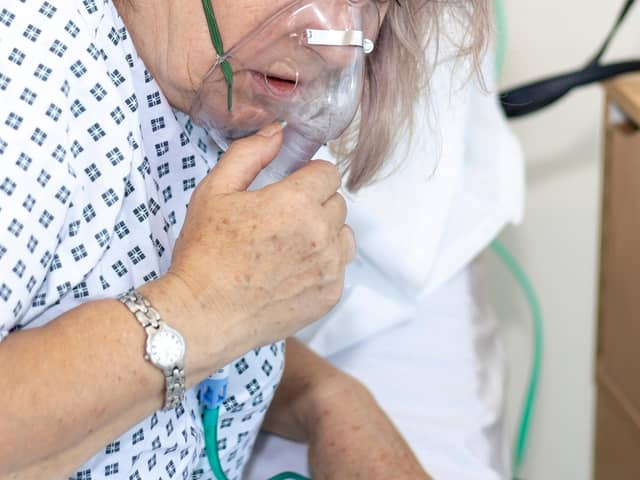 Woman in hospital with breathing difficulties using a resperation mask