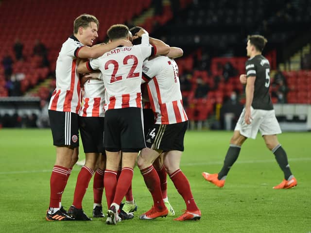 SHEFFIELD, ENGLAND - DECEMBER 17: David McGoldrick of Sheffield United celebrates with team mates after scoring their sides first goal during the Premier League match between Sheffield United and Manchester United at Bramall Lane on December 17, 2020 in Sheffield, England. The match will be played without fans, behind closed doors as a Covid-19 precaution.  (Photo by Peter Powell - Pool/Getty Images)