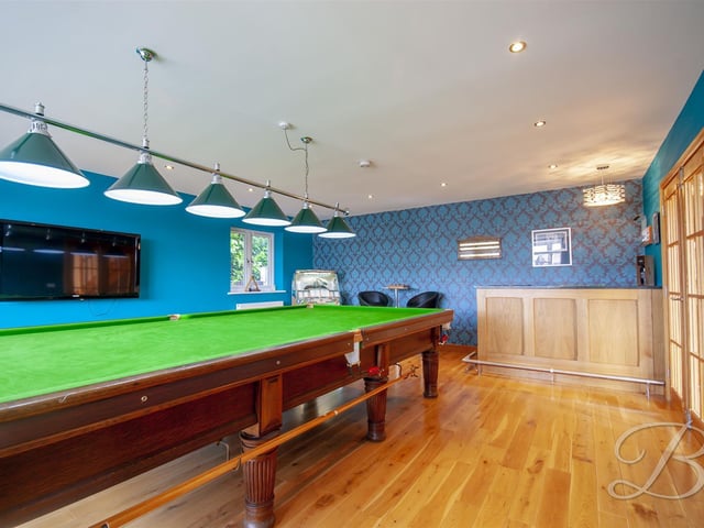 The large, front lounge is in use as a games room, complete with bar.