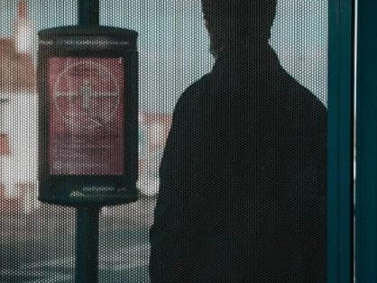 A man waiting at a bus stop.
