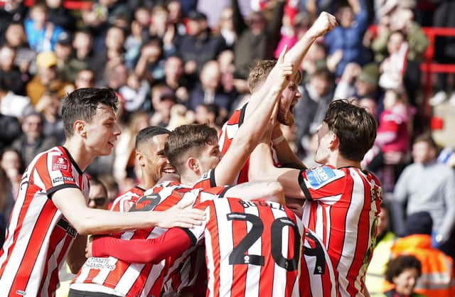 Tommy Doyle is mobbed by his Sheffield United teammates after booking their place at Wembley: Simon Bellis / Sportimage