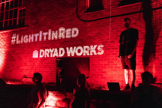 Joe (top right) and others at Dryad Works when it was lit up red in August. Photo by Rhys Belding/Blueshift Studios