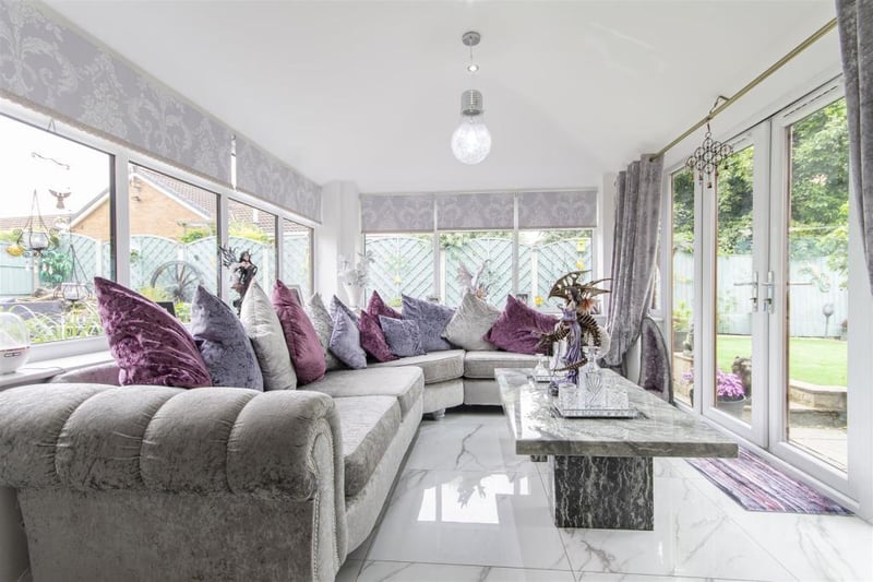 The garden room is described as a fantastic, triple-aspect garden room, having a vaulted ceiling and fitted with Carrera marble tiled flooring. French doors overlook and open onto the rear patio.
