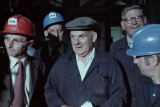 Harold Dransfield, centre, at his retirement presentation, made by the man in the red hard hat