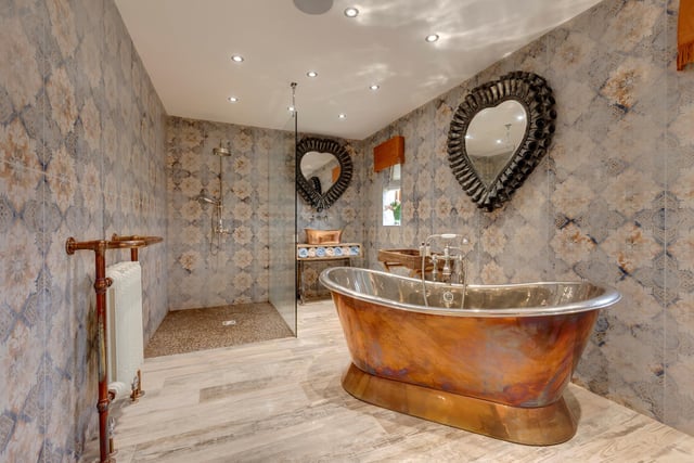 There are eight bathrooms located throughout the property, with this en-suite featuring a freestanding Hurlingham copper bath, a double width walk-in shower and built-in speakers.
