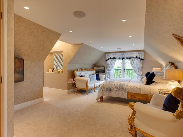 The property boasts six bedrooms in total, including this stunning master bedroom which features its own private sitting room and en-suite with a bathtub and walk-in shower.