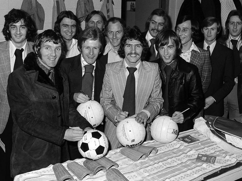 Stags players sign footballs.