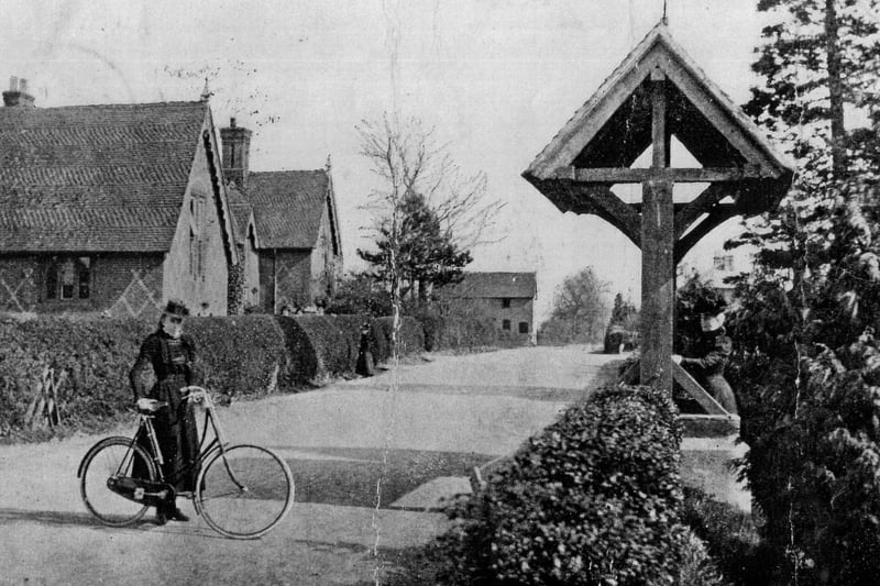 An unknown woman on a bike outside St Barnabas Church in 1904, with the village school (now Swanmore CE Primary) in the background.