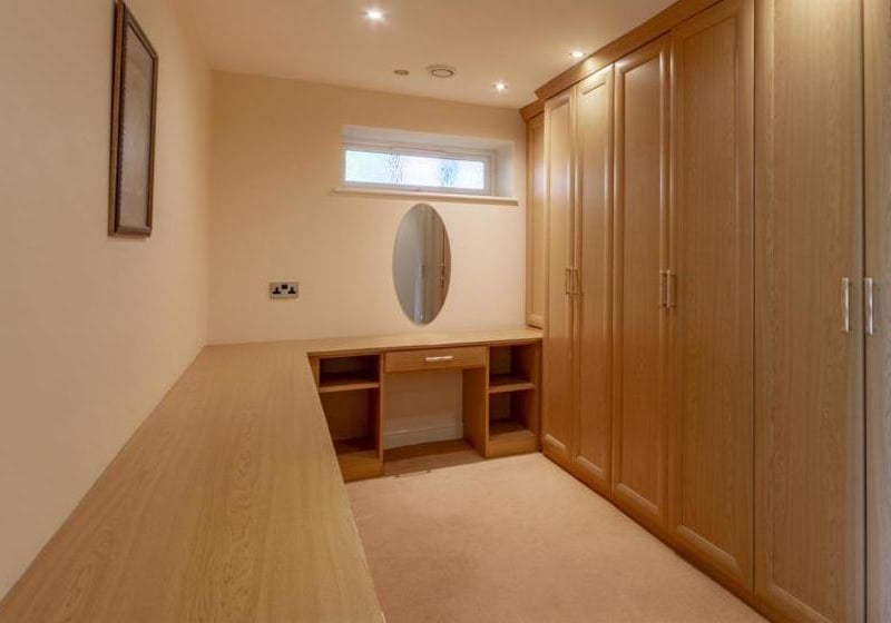 A carpeted dressing-room, just off the master bedroom. It has space for additional storage and fitted furniture.