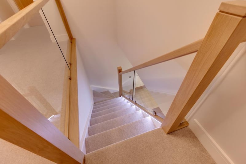 A staircase with an oak hand rail, glazed balustrading and feature lighting rises to the first-floor landing, which has front and rear-facing obscured glazed panels, recessed lighting, pendant light point and under-floor heating.