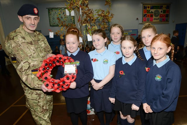 Corporal, Derek Lynn is presented with a poppy wreath  by Year 6 pupils from Hylton Castle Primary school, Chloe Loiver, Jessica McCann, Neive Martin, Talia Andrews, Delta Cooper and Tegan Lines. Does this bring back memories from 2014?