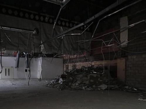 Loose pipework hangs down from the ceiling.