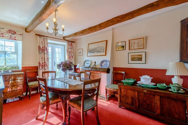 The dining room has windows to the front and back, French doors opening to the courtyard, exposed timbers to the ceiling and a feature chimney breast.