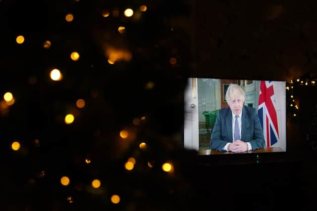 Prime Minister Boris Johnson appears on a TV screen during a pre-recorded address to the nation from Downing Street, about the booster vaccine programme. Picture date: Sunday December 12, 2021. PA Photo.