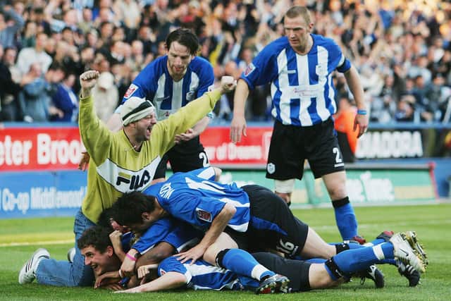 Jon-Paul McGovern of Sheffield Wednesday is mobbed by players and one spectator after scoring what proved to be the only goal in their home playoff final win over Brentford in 2005.