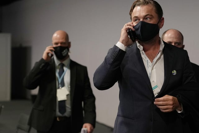 The U.S. actor spoke on a mobile phone as he walked through the corridor during the COP26 U.N. Climate Summit.