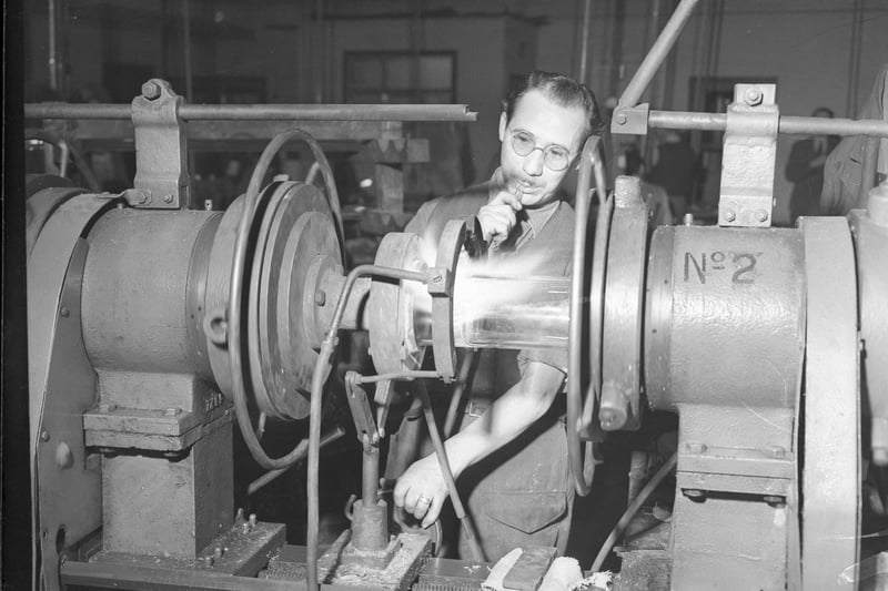 A worker welds a glass tube on a lathe in the Pallion factory of James A Jobling and Co in 1952.