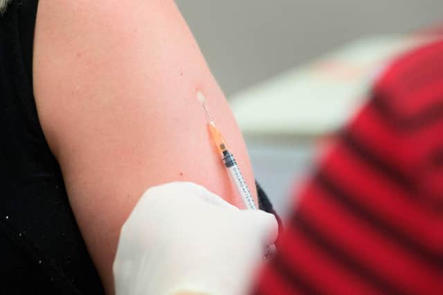 A volunteer is injected with a syringe containing either the vaccine or a placebo (Photo by RODGER BOSCH/AFP via Getty Images)