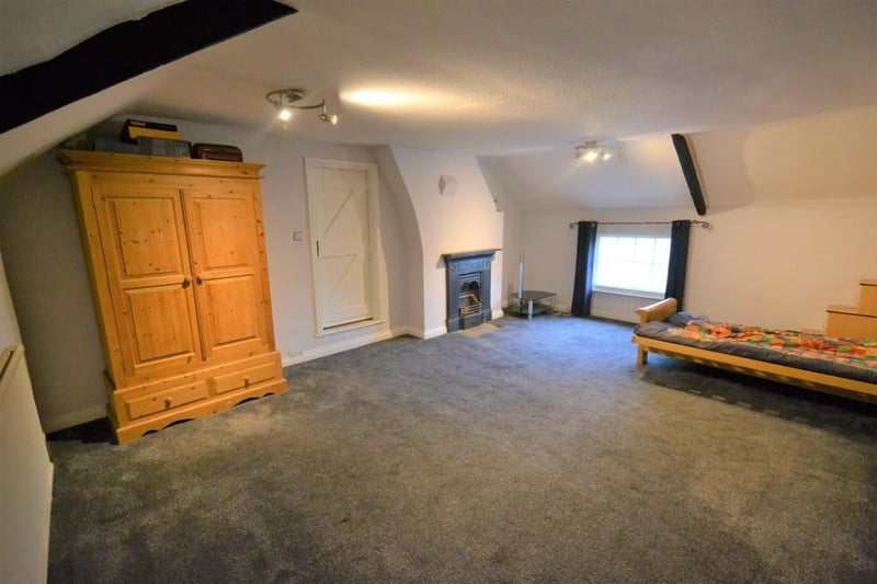 A spacious front facing double bedroom with part vaulted ceiling and exposed oak beams. Enjoying a pleasant view from a pivoting wooden window. Feature open cast fireplace.  A further door opens to the second floor sitting room.