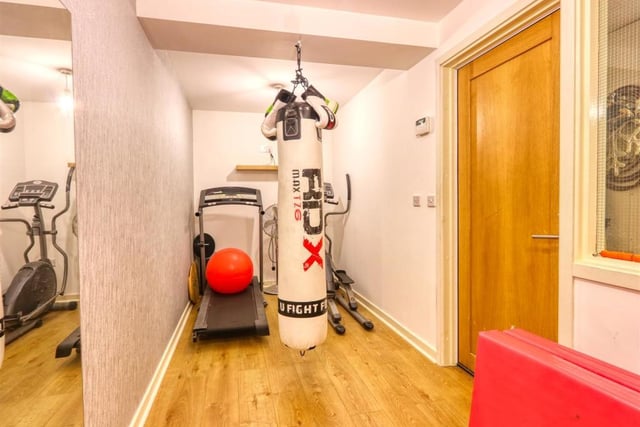 Stairs lead down from the entrance hall to the gym where there is a storage cupboard and a door leading to the garage.