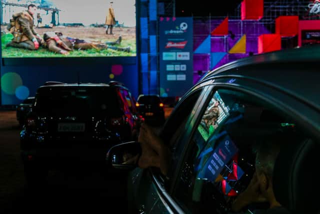 SAO PAULO, BRAZIL - JULY 23: Spectators in their vehicle attend a cine drive-in movie screening of "1917" amidst the coronavirus (COVID - 19) pandemic at the Pacaembu stadium on July 23, 2020 in Sao Paulo, Brazil. Sao Paulo authorities deactivated the field hospital two weeks ago Amidst the Coronavirus (COVID - 19) Pandemic. (Photo by Miguel Schincariol/Getty Images)