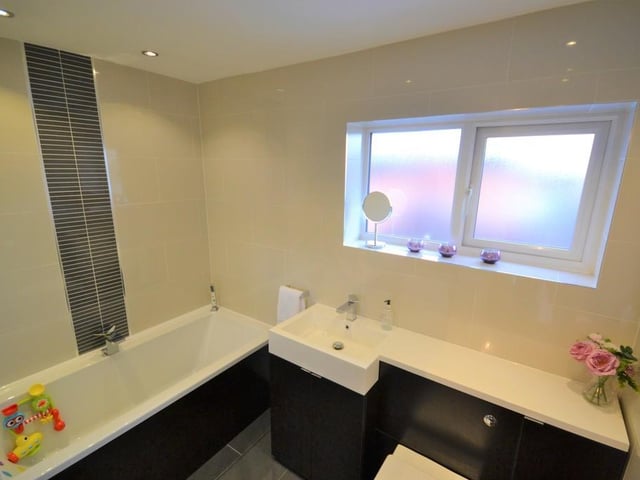 Family bathroom - A stylish and immaculately presented family bathroom, incorporating a bath with chrome mixer tap, matching wash basin with chrome mixer tap and low level w.c. inset to a vanity unit, chrome heated towel rail and complemented with attractive porcelain wall and floor tiles.