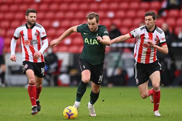 Tottenham Hotspur striker Harry Kane (C) runs with the ball as Sheffield United's Chris Basham (R) and Oliver Norwood (L) chase after him (Photo by STU FORSTER/POOL/AFP via Getty Images)