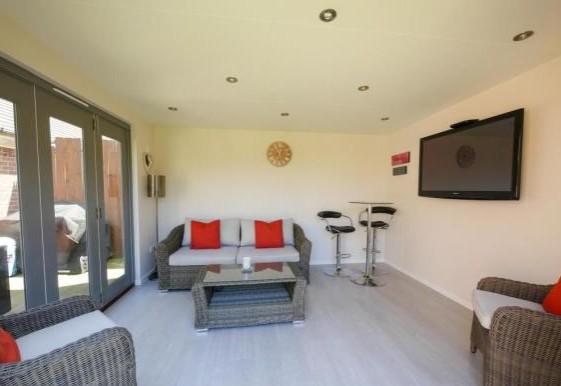 A stunning detached studio with two sets on bi-folding doors opening to the garden, recessed spot lighting, provision for a wall mounted tv and laminate floor.