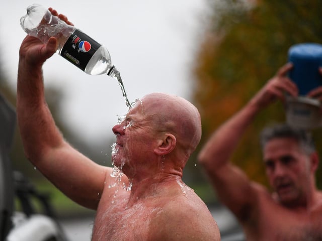 Open water swimming enthusiasts pour warm water over themselves following an early morning swim in Loch Lomond , Trossachs, Scotland. A new study from the UK Dementia Research Institute found that the blood of regular winter swimmers contains a "cold-shock" protein that wasn't found in that of people who did other cold-weather exercise on dry land.