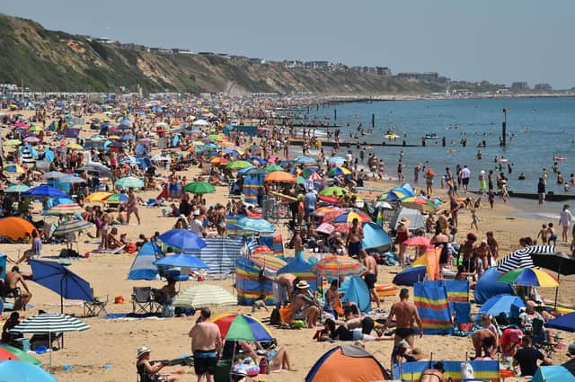 Beachgoers enjoy the sunshine as they sunbathe and play in the sea on Boscombe beach in Bournemouth, southern England, on June 25, 2020.