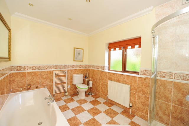 The sizeable bathroom has a separate shower enclosure and bathtub.