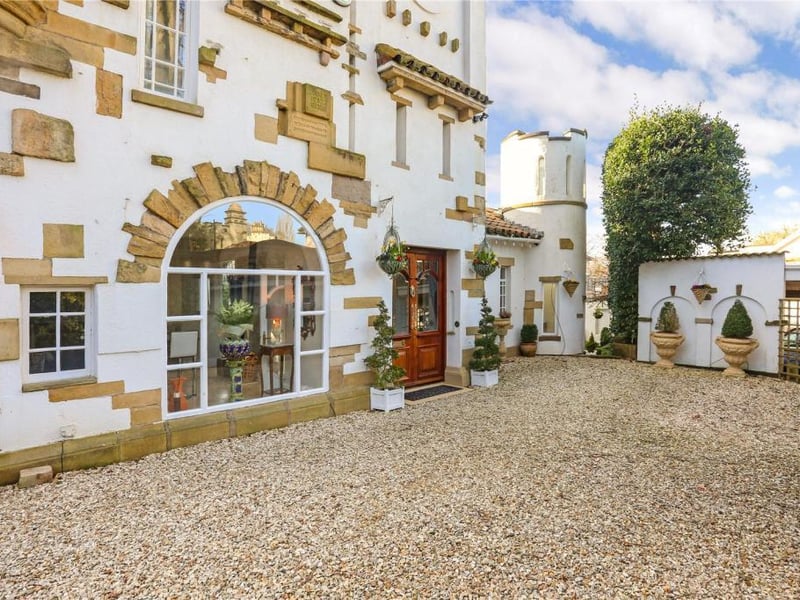 A gravelled driveway leads to the front door and provides parking for three cars.