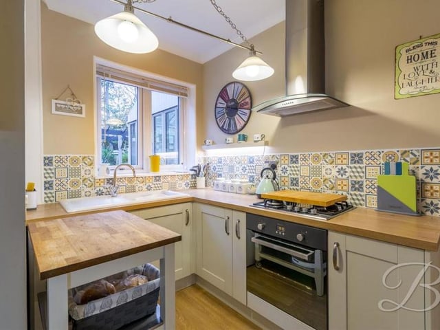 'Bless This Home With Love And Laughter' says the sign on the wall of the kitchen, which comes complete with a wide range of matching units and cabinets, with complementary work surfaces over. There is also an oven, gas hob with stainless-steel cooker hood, inset sink and drainer, and space and plumbing for a washing machine.