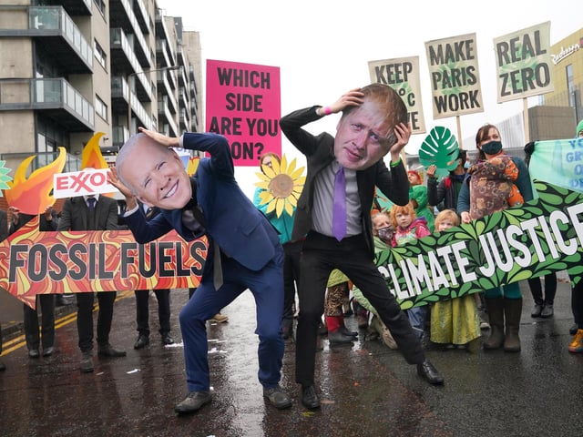 Climate Justice Activists at the Cop26 Gates asking delegates as they make final decisions, "Are You With Us Or With Fossil Fuels?" during the official final day of the Cop26 summit in Glasgow. Picture date: Friday November 12, 2021.