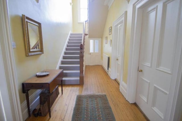 The long hallway runs throughout the middle of the house, with a staircase at the front and back.