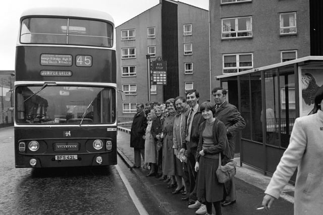 Passengers at the bus stop as the 45 bus draws up at Dumbiedykes housing scheme in Edinburgh, June 1980.