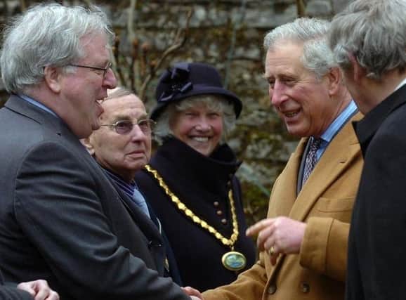King Charles III meeting and greeting local dignitaries.