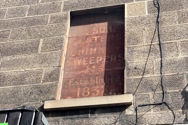 The faded lettering of a chimney sweeper advert in Morrison Street.