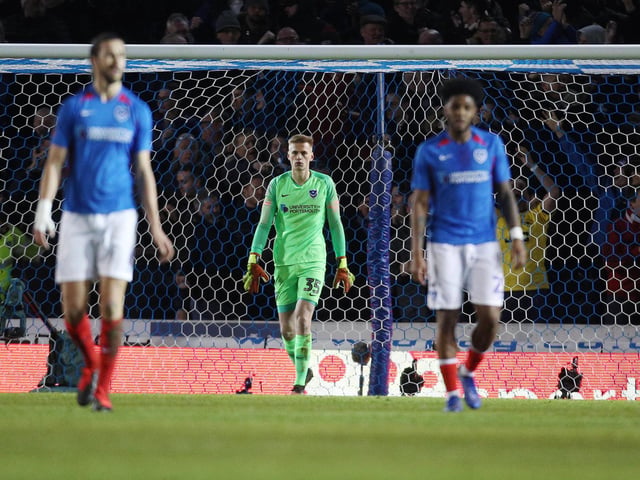Portsmouth's Alex Bass dejected after Arsenal's Sokratis Papastathopoulos scores the first goal of the match