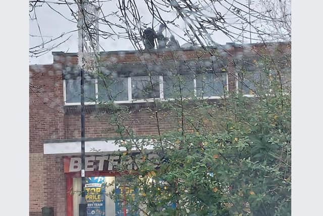 Pictures taken by concerned locals show three people on the top of the Bet Fred shop on Market Street, Woodhouse, on Friday, with hoods up. It is thought they had climbed on to the top, before throwing things down from the top of the building.
