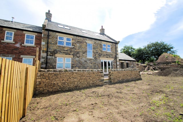To the rear, a raised terrace steps down to the garden which adjoins open countryside, commanding long-distance views.