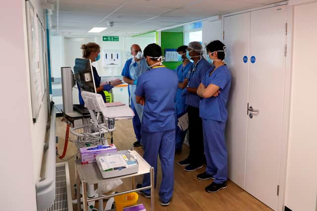 Members of medical staff wearing PPE (personal protective equipment), including face masks, aprons and gloves as a precautionary measure against COVID-19(Photo by Steve Parsons / POOL / AFP) (Photo by STEVE PARSONS/POOL/AFP via Getty Images)