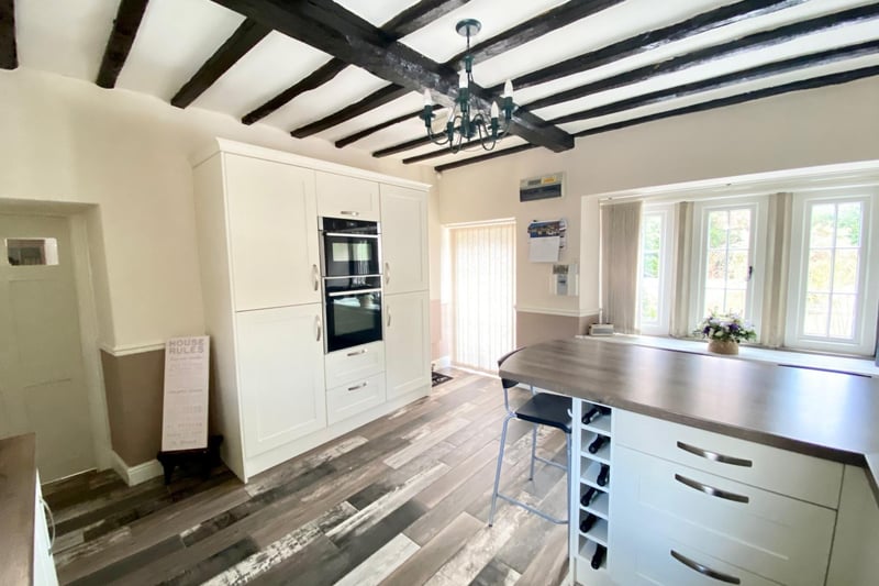 Original exposed wooden ceiling beams, fitted with a bespoke range of high-quality base and eye level units with fitted contrasting worktop space and breakfast bar.