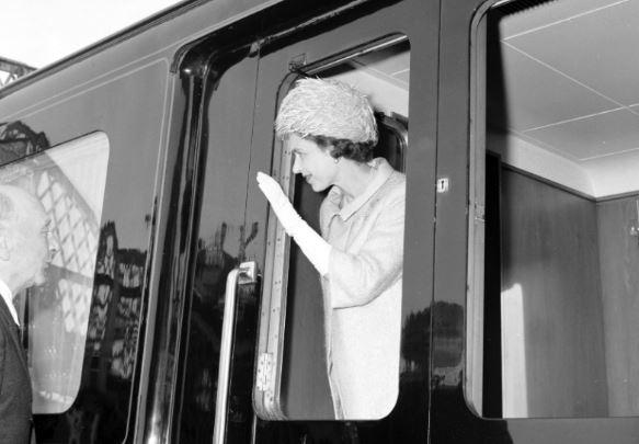 Queen Elizabeth II waves from her train at Stow station.