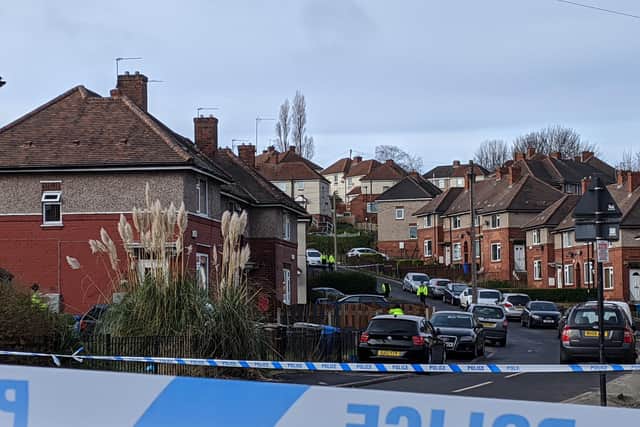The police cordon in place on Saturday morning. Two officers stood outside one property on Woodhouse Road within the cordon.