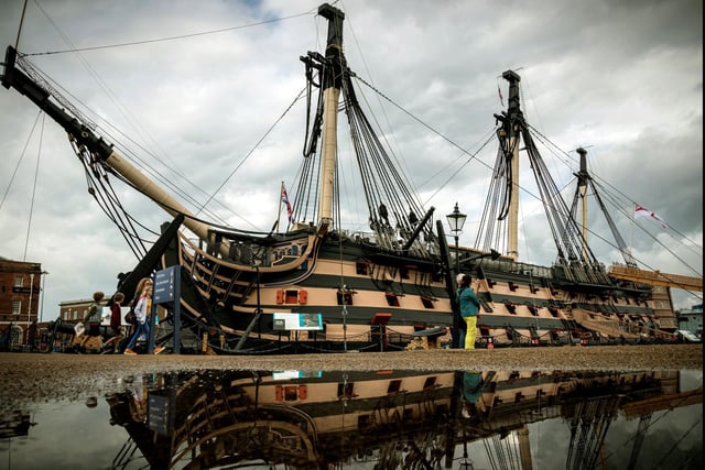 HMS Victory reflected in the water after heavy rain at Portsmouth Historic Dockyard in 2019.