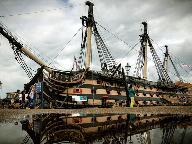 HMS Victory reflected in the water after heavy rain at Portsmouth Historic Dockyard in 2019.