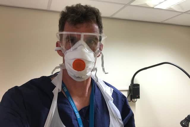 Dr Ollie Hart donning his PPE at Sloan Medical Centre